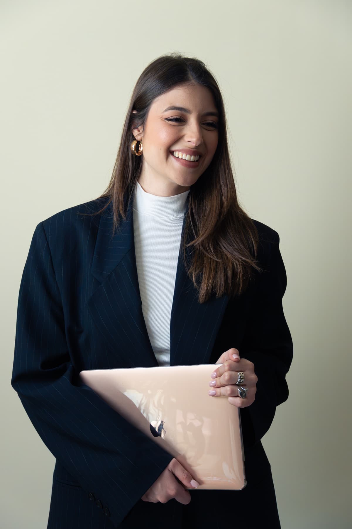 Chiara Ferrara sorride mentre tiene il suo laptop
